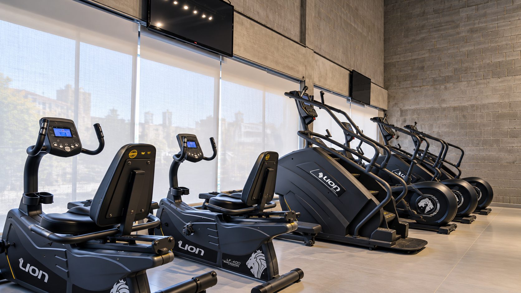 Bicicletas reclináveis e escadas de cardio diante das janelas da academia